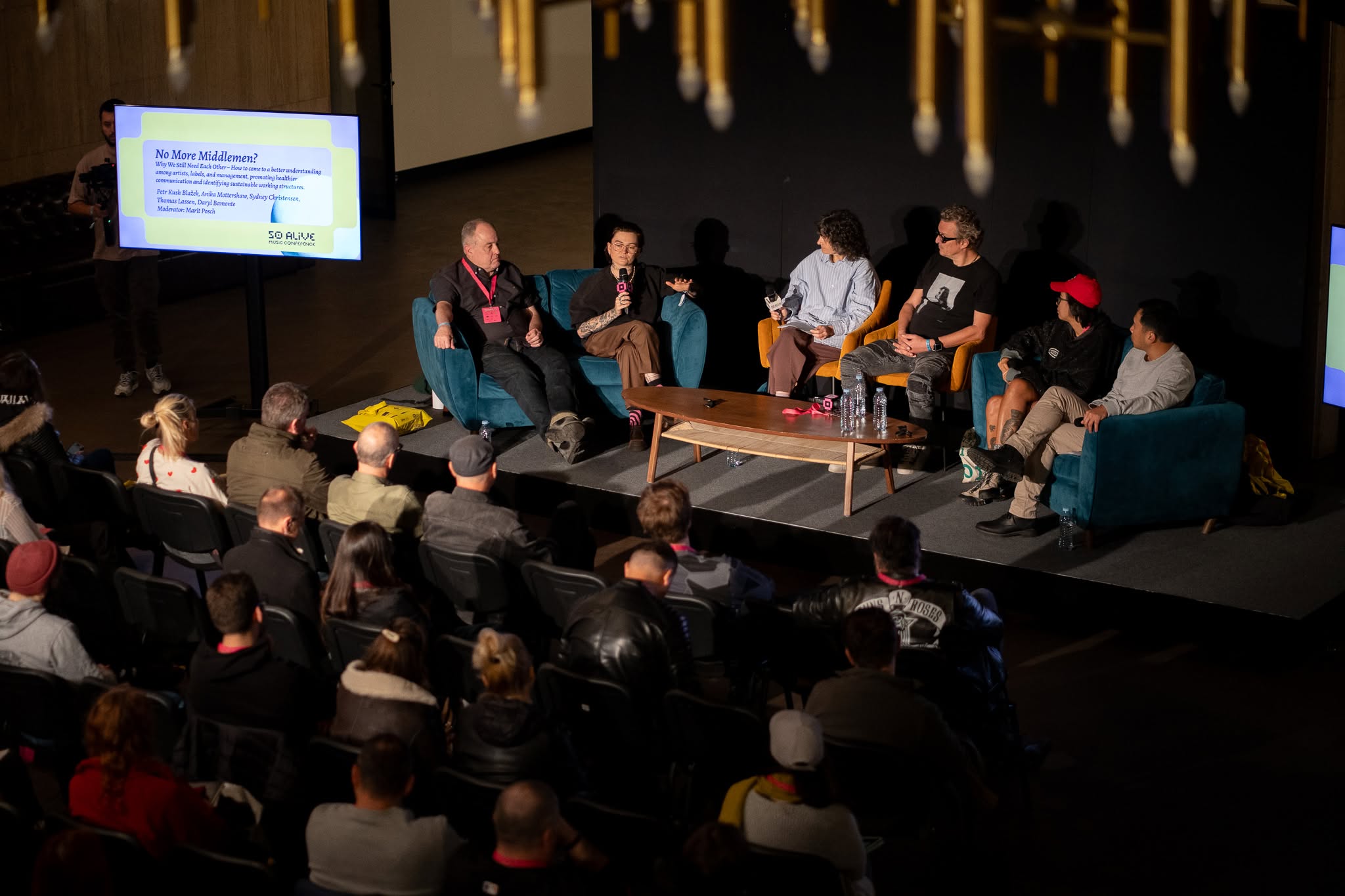 Panel discussion at SoAlive Music Conference with speakers seated on stage in front of an audience